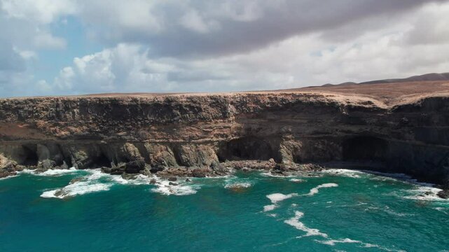 Drone shot of the Ajui Caves on the island of Fuerteventura, where the ocean crashes against the shore. Canary Islands, Spain.
