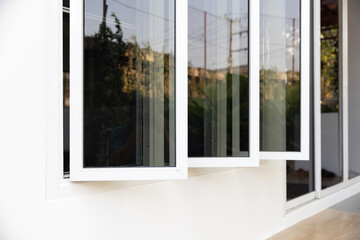 Three panel aluminium casement window stay on white wall.