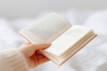 Fototapeta premium close-up of person holding open book handwritten notes in margins