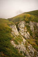 Mountain range with visible silhouettes through the morning colorful fog.