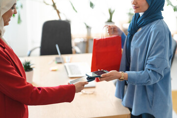 Two people are using their phones to make a contactless payment. The person in blue is paying $17.25 to the person in red, likely for a shared expense or service.