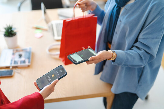 A shopper is using their phone to make a contactless payment after a purchase. It's a convenient way to pay, especially when you're on the go.