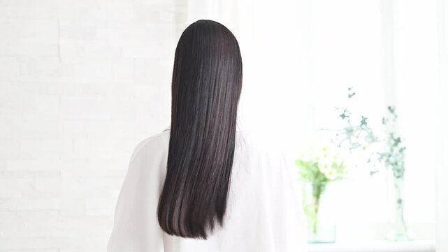 Long shiny black hair without face behind woman's back beautiful straight hair swinging hair with cuticles slow animation of image of hair care etc.
