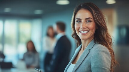 Obraz premium Confident businesswoman with long brown hair smiling in a modern office setting.