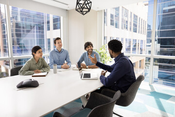 Group of happy multiethnic businesspeople engaged in professional discussion in modern conference...