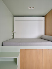 Compact modern bedroom with foldable bed, minimalist light green and wood design, smart space-saving interior
