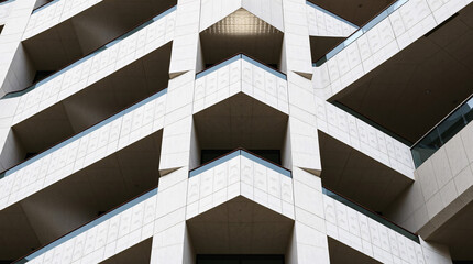 Modern geometric architecture of a white building with repetitive angular balconies and clean minimalistic design.