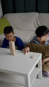 Brother and younger brother play board games together.