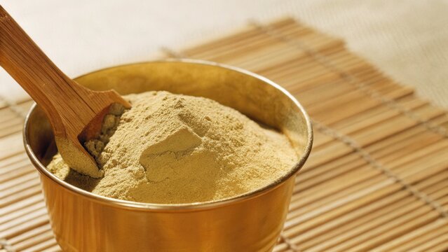 Muted Tones Style. Close-up of triphala powder mixed in a copper container.