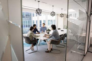 Group of multinational business partners discussing merger or new profitable deal, explaining...