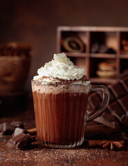 Hot chocolate with whipped cream in a glass mug.