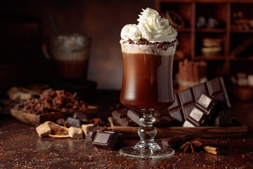 Hot chocolate with whipped cream in a glass mug.