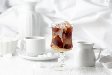 Iced coffee with cream and cup of black coffee.