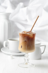 Iced coffee with cream and cup of black coffee.