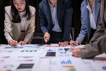 A group of people are working on a project and writing on a table