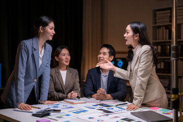 A woman is talking to a group of people at a table