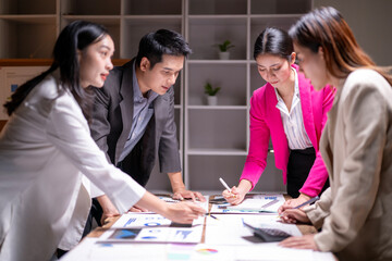 A group of people are sitting around a table with papers and a calculator