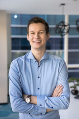 Office portrait of businessman, staff member posing with arms-crossed in office, look at camera...