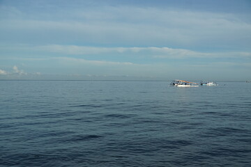 Calm fishing boats on serene ocean waters coastal landscape photography tranquil environment wide-angle view nature's beauty