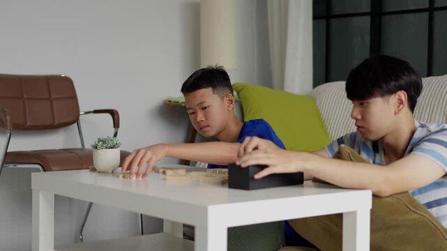 Brother and younger brother play board games together.