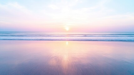 Obraz premium Calm ocean waves gently washing onto a sandy beach during a beautiful pastel sunset with pink and purple reflections in the water.