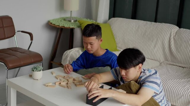 Brother and younger brother play board games together.