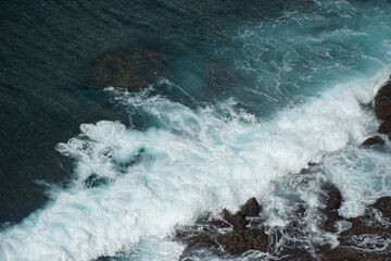 Waves crashing on rocky shore coastal area nature photography serene atmosphere aerial view ocean dynamics