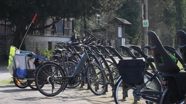 Row of different bicycles on a modern parking lot in a walking park.