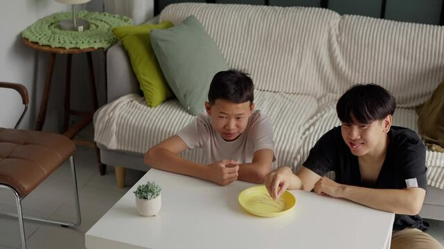 Brother sitting and eating snacks at home.
