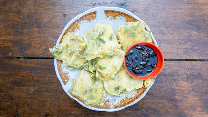Gorengan fried tofu on white plate served with spicy soy sauce is traditional authentic typical snack from Java.