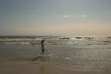 Beautiful tween walking through ocean waves Outer Banks North Ca
