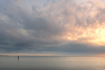 Profile of person walking on sandbar at sunset Cape Hatteras Nat