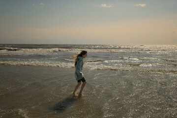 Side view tween girl walking in waves Cape Hatteras National Sea