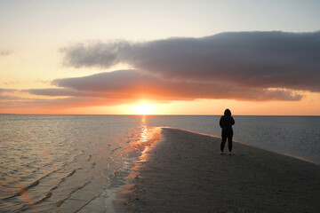 Behind person in hood watching sunset on the sound Cape Hatteras