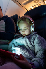 Young girl stares at a screen on an airplane