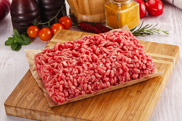 Raw minced beef meat over board