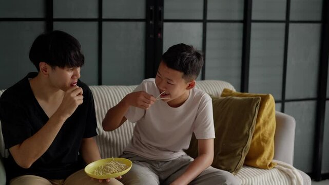 Brother sitting and eating snacks at home.