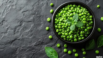 Vibrant green peas in a black bowl presented on dark textured backdrop