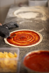 Spreading Tomato Sauce on Pizza Dough