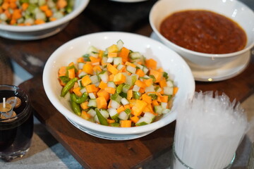 A bowl of pickles as a topping for the main course at a buffet event