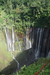 Majestic waterfall cascading over lush green hills indonesia nature photography tropical environment scenic view beauty of nature