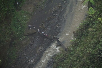 Crossing a river locals navigate the jungle terrain aerial view nature scene remote environment