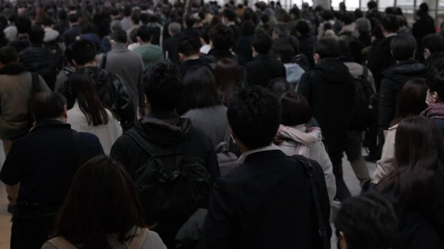 朝の通勤するビジネスマンたちの後ろ姿のスローモーション　東京