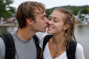 Fototapeta premium In a delightful setting by the water, a young couple shares a playful kiss, their joyful expressions highlighting the love and happiness they bring to each other.