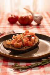Bruschetta with tomatoes and rosemary on rustic table