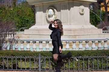 Portrait of blonde woman with curly hair, young and beautiful dressed in black. The woman is happy...