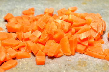 A mountain of boiled carrots, cut into pieces, lies on the table.