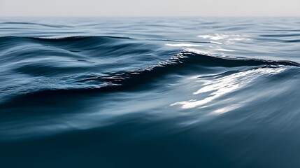Fototapeta premium Close-up of gentle ocean waves with soft reflections on calm blue water