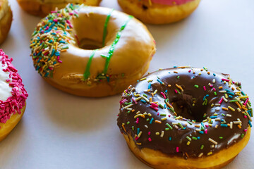 Glazed and decorated donuts in a box, showcasing a variety of flavors and toppings, with vibrant icing colors, set on a wooden table, perfect for a sweet treat or dessert