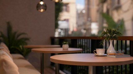 A coffee cup on round stool table with fabric sofa on the cafe terrace or balcony.